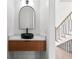 Modern powder room boasts a unique black sink, arched mirror, and textured vanity at 1857 Defoor Ave, Atlanta, GA 30318