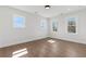 Bright, minimalist bedroom with hardwood floors, white walls, and natural light streaming through three windows at 1857 Defoor Ave, Atlanta, GA 30318