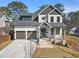 Charming two-story home featuring a symmetrical design, three-car garage and a well-manicured front lawn at 1857 Defoor Ave, Atlanta, GA 30318