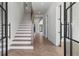 Bright foyer with hardwood floors, a staircase, and elegant glass front doors at 1857 Defoor Ave, Atlanta, GA 30318
