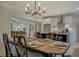 Open dining area with kitchen view, set table, and contemporary lighting fixture at 220 Nicklaus Cir, Social Circle, GA 30025