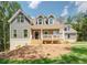 Inviting two-story home featuring a charming front porch and beautifully landscaped yard with a combination of grass and pine straw at 220 Nicklaus Cir, Social Circle, GA 30025