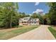Inviting two-story home with a long driveway and beautiful landscaping at 220 Nicklaus Cir, Social Circle, GA 30025
