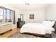 Bright bedroom featuring a large window with an urban view, hardwood floors, and minimalist decor at 300 W Peachtree St # 10D, Atlanta, GA 30308