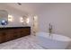 An elegant bathroom with a double vanity, soaking tub, and stylish hexagon tile flooring at 581 Sherwood Ne Rd, Atlanta, GA 30324