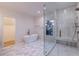 A luxurious bathroom featuring a soaking tub, glass-enclosed shower, and stylish tile flooring at 581 Sherwood Ne Rd, Atlanta, GA 30324