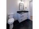 Modern bathroom boasts black tile floors, white vanity with dark countertop, and a sleek mirror at 581 Sherwood Ne Rd, Atlanta, GA 30324