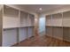 Spacious closet featuring open storage shelves with metal hanging rods and wooden floors at 581 Sherwood Ne Rd, Atlanta, GA 30324