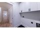 Hallway view of the laundry room with white shaker cabinets, and wood flooring at 581 Sherwood Ne Rd, Atlanta, GA 30324