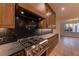 Gourmet kitchen featuring black backsplash, pot filler, stainless steel range, and custom wood cabinets at 581 Sherwood Ne Rd, Atlanta, GA 30324