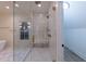 A glass shower enclosure in a bathroom with a window, bench, and light-colored tile at 581 Sherwood Ne Rd, Atlanta, GA 30324