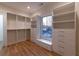 Bright walk-in closet offering custom storage solutions and a window seat with drawers at 581 Sherwood Ne Rd, Atlanta, GA 30324