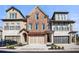 Attractive townhome row features stone and brick exterior, two-car garages, and manicured landscaping at 202 Via Lucca, Woodstock, GA 30188