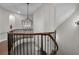 Hallway with staircase, wood railing, and modern lighting at 202 Via Lucca, Woodstock, GA 30188