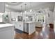 Open-concept kitchen and living area features a large island, hardwood floors, and white cabinets at 202 Via Lucca, Woodstock, GA 30188