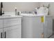 Laundry room with front load washer and dryer, sink, and white cabinets at 202 Via Lucca, Woodstock, GA 30188