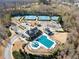 Aerial view of community pool and tennis courts surrounded by wooded landscape at 6615 Grove Meadows Ln, Cumming, GA 30028