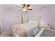 Bedroom with lilac walls, ceiling fan, and a pink throw at 6615 Grove Meadows Ln, Cumming, GA 30028