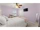 Bedroom with lilac walls, ceiling fan, and TV at 6615 Grove Meadows Ln, Cumming, GA 30028