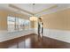 Bright dining area with hardwood floors, wainscoting, and a modern chandelier at 6615 Grove Meadows Ln, Cumming, GA 30028