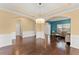 Elegant dining room with tray ceiling, hardwood floors, and views into the living room at 6615 Grove Meadows Ln, Cumming, GA 30028