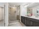 Luxurious bathroom with a glass shower, double sinks, dark cabinets, and modern finishes at 1566 Ridgebrook Downs, Mableton, GA 30126