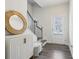 Bright and inviting foyer with hardwood floors, white cabinet, round mirror and staircase at 1566 Ridgebrook Downs, Mableton, GA 30126