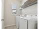 Functional laundry room with modern appliances, storage shelves, and patterned tile flooring at 1566 Ridgebrook Downs, Mableton, GA 30126