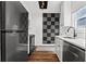 Modern kitchen with stainless steel appliances, white cabinetry and tile backsplash at 1600 Temple Ave, Atlanta, GA 30337