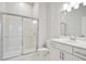 An all-white bathroom features a glass shower, a toilet, and a vanity sink at 1891 Audubon Park Ln, Decatur, GA 30033