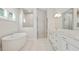 Bright bathroom featuring a soaking tub, large mirror over dual vanity, and a glass enclosed shower at 1891 Audubon Park Ln, Decatur, GA 30033