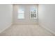 Bedroom with plush carpeting, neutral paint, and two large windows providing ample natural light at 1891 Audubon Park Ln, Decatur, GA 30033