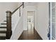 Inviting hallway with hardwood floors, wooden staircase, and neutral walls, leading to the living spaces at 1891 Audubon Park Ln, Decatur, GA 30033