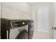 Modern laundry room with full-size, front-loading washer and dryer with wire rack shelf above at 1891 Audubon Park Ln, Decatur, GA 30033
