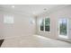 A large, airy living room with three windows and a glass door offer abundant natural light at 1891 Audubon Park Ln, Decatur, GA 30033