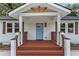 Inviting front porch with a beautifully stained wood floor, porch railing, and light blue front door at 253 Mcintosh Avenue Ne, Marietta, GA 30060