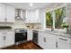 Well-lit kitchen with white cabinetry, stainless steel appliances, granite countertops, and a stone backsplash at 253 Mcintosh Avenue Ne, Marietta, GA 30060
