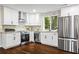 Modern kitchen featuring white cabinetry, stainless steel appliances, granite countertops, and stone backsplash at 253 Mcintosh Avenue Ne, Marietta, GA 30060