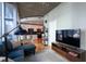 Comfortable living room connected to a modern kitchen, with a TV, couch and rug at 923 Peachtree Ne St # 932, Atlanta, GA 30309