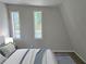 Cozy bedroom showcasing a bed with stylish gray accents and two windows at 1920 Moores Mill Nw Rd, Atlanta, GA 30318