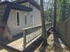 Exterior featuring a weathered deck, siding, and a tree-lined property boundary at 1920 Moores Mill Nw Rd, Atlanta, GA 30318