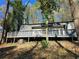 Exterior view of home, highlighting its large deck, AC unit, and tree-lined surroundings at 1920 Moores Mill Nw Rd, Atlanta, GA 30318