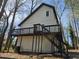 Two-story home showcasing a spacious deck and wooden stairs surrounded by mature trees at 1920 Moores Mill Nw Rd, Atlanta, GA 30318