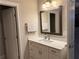 A bright bathroom features a modern vanity with stone countertop and decorative mirror at 2021 Towneship Trl, Roswell, GA 30075