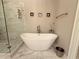 This bathroom features marble tile, a glass shower enclosure, and a modern tub at 2021 Towneship Trl, Roswell, GA 30075