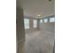 A spacious carpeted bedroom with ample natural light from multiple windows, perfect for relaxing at 2021 Towneship Trl, Roswell, GA 30075