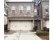 Two-car garage with brick facade and a black awning offering curb appeal at 2021 Towneship Trl, Roswell, GA 30075