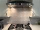 Close-up of the kitchen range featuring modern Monogram range hood and subway tile backsplash at 2021 Towneship Trl, Roswell, GA 30075