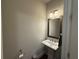 Cozy powder room features a pedestal sink, a wood-framed mirror, and neutral color palette at 2021 Towneship Trl, Roswell, GA 30075