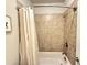 This bathroom features a shower and tub with neutral toned tile and modern fixtures at 2021 Towneship Trl, Roswell, GA 30075